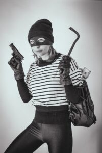 Black and White Photo of a Burglar Holding a Gun